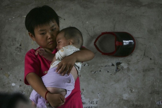 9 juillet 2006: Wang Huaixue porte un bébé à l’orphelinat de Wang Jiayu dans la province d’Anhui. Des millions d’orphelins reconnus ou non par l’administration sont victimes du système social chinois. (China Photos/Getty Images)