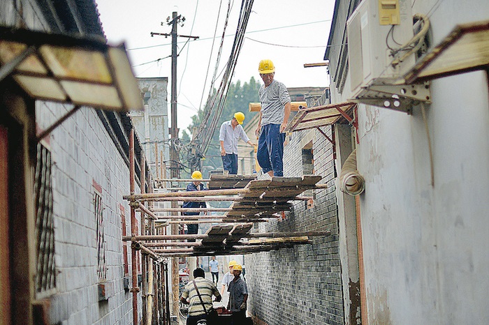 Des ouvriers du bâtiment sur un chantier dans une ruelle de Pékin, le 24 mai 2014. (Whang Zhai/AFP/Getty Images)