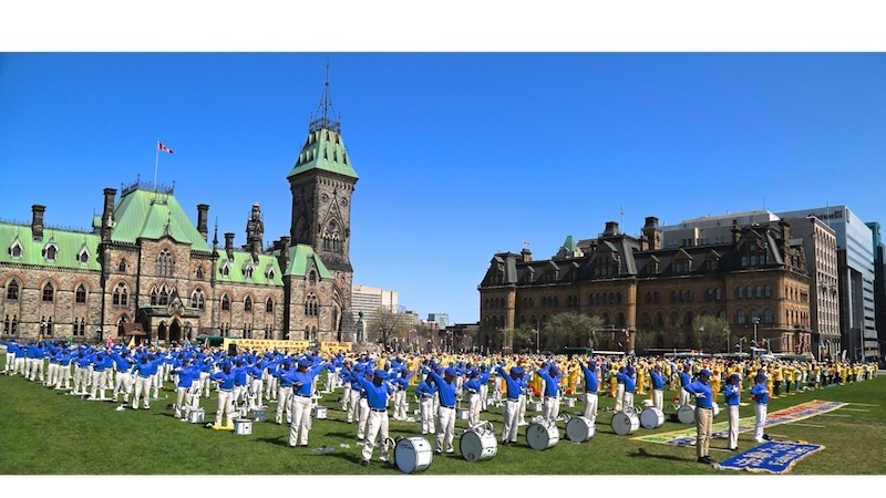 Des pratiquants de Falun Dafa, avec des membres de la fanfare Tian Guo, ont pratiqué leurs exercices sur la Colline du Parlement le 6 mai 2015 à Ottawa. (Donna He/Epoch Times) 