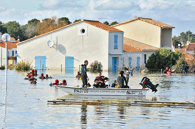 Des sauveteurs secouristes fouillent les maisons inondées, le 2 mars 2010, à La Faute-sur-Mer, après la tempête Xynthia. Des vents de forte tempête et des pluies torrentielles avaient détruit les routes et les maisons le long de la côte atlantique. (Frank Perry/AFP/Getty Images)