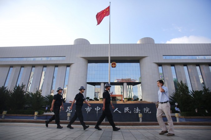 Une patrouille de police à la porte de la Cour intermédiaire de justice de Kunming, dans la province du Yunnan au sud-ouest de la Chine le 12 septembre 2014. (STR / AFP / Getty Images)