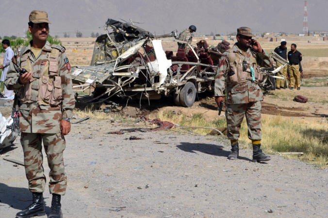 Des responsables de la sécurité pakistanaise montent la garde près d’un véhicule des forces de sécurité détruit dans un attentat à la bombe dans la banlieue de Quetta, la capitale agitée de la province du Baloutchistan, le 23 mai 2013. Le régime chinois est en train de construire un réseau commercial à travers le Baloutchistan. (Banaras Khan/AFP/Getty Images)