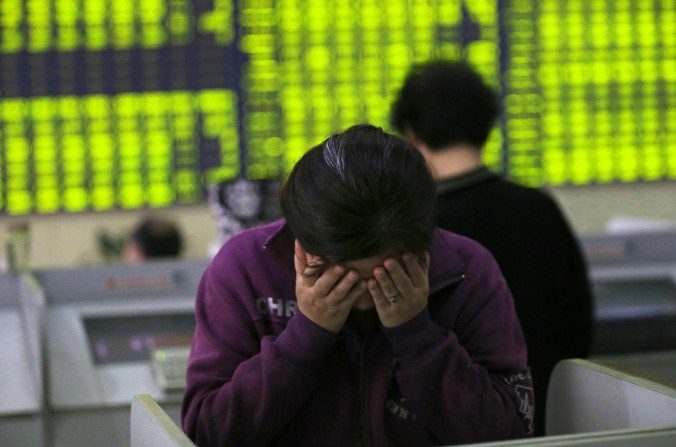 Une femme se tient la tête dans les mains dans une maison de courtage à Nantong, dans la province du Jiangsu de la Chine le 8 juillet 2015 (Chinatopix via AP)