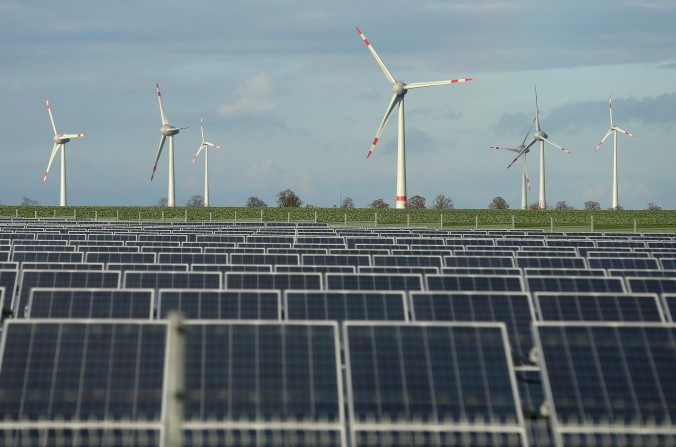 Des éoliennes derrière un parc d'énergie solaire, près de Werder, en Allemagne, le 30 octobre 2013. (Sean Gallup/Getty Images)