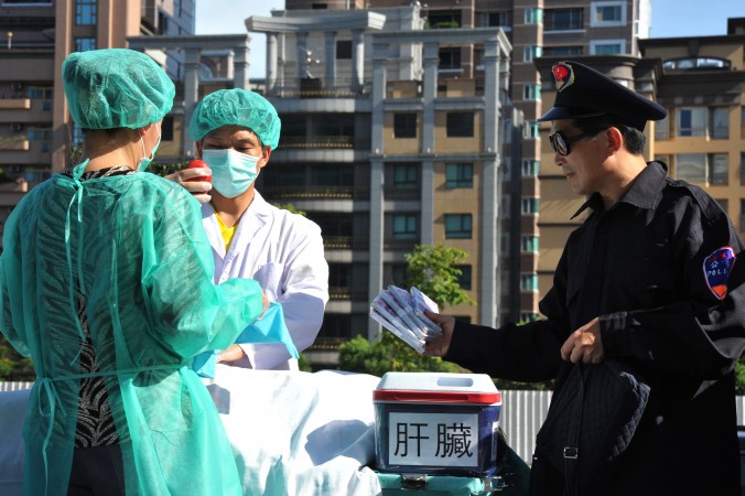 Les pratiquant de la discipline spirituelle Falun Gong simulent des vols d'organes humains  lors d'une manifestation à Taipei, le 20 juillet 2014. (Mandy Cheng / AFP / Getty Images)