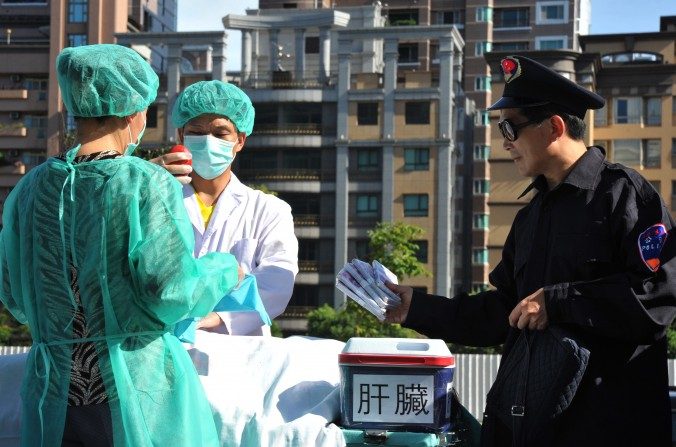 Des pratiquants de Falun Gong simulent une scène de vol d'organes humains destinés à la revente, lors d'une manifestation à Taipei, le 20 juillet 2014. (Mandy Cheng/AFP/Getty Images)