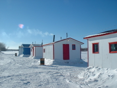  La dernière étape avant de pouvoir pêcher dans le confort d’un chalet chauffé est de pousser la neige pour bien bloquer l’espace entre la glace et la cabane, pour s’assurer que l’air ne passe pas dessous. (Association des pourvoyeurs de pêche aux petits poissons des chenaux) 