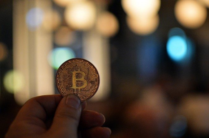 Un homme tient une pièce de bitcoin. Les membres du club d’échange de bitcoin tenaient une réunion à Tokyo le 27 février 2014 (Yoshikazu Tsuno/AFP/Getty Images)