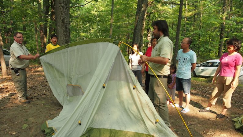 Les gardes-parcs montrent comment monter la première tente. (Nathalie Dieul/Époch Times)