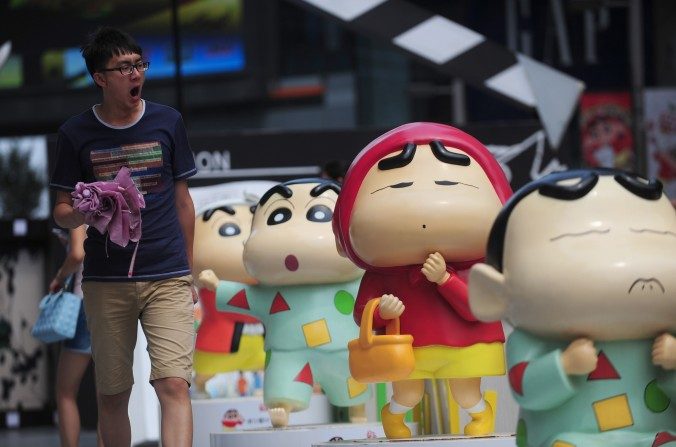 Un homme qui passe devant  des sculptures lors de l’exposition Shin-chan à Shenyang, province du Liaoning au nord-est de la Chine, le 11 juillet dernier (STR / AFP / Getty Images)