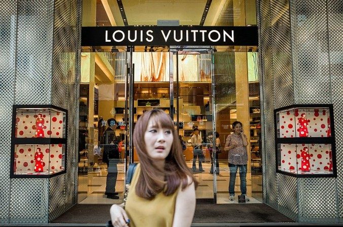 Une cliente passe devant un magasin Louis Vuitton à Hong Kong, en septembre 2012. (PHILIPPE LOPEZ / AFP / Getty Images)