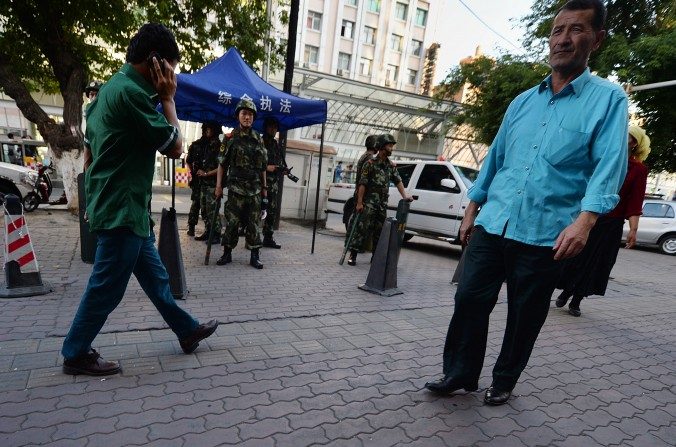 La police paramilitaire chinoise monte la garde dans la région à minorité musulmane ouïghoure à Urumqi, province du Xinjiang le 30 juin 2013. Après les attaques terroristes du 13 novembre 2015 à Paris, les autorités chinoises n’ont cessé d’associer en permanence les mots Ouïghours et terrorisme. (Mark Ralston/AFP/Getty Images)