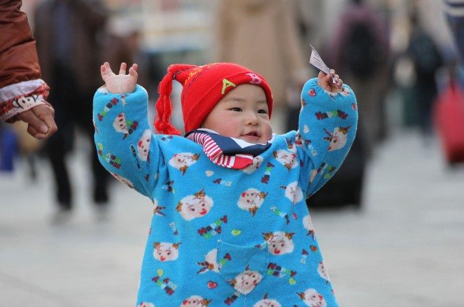 Un enfant avec un billet de train à la gare de Qingdao, le 13 janvier 2014. (STR / AFP / Getty Images)