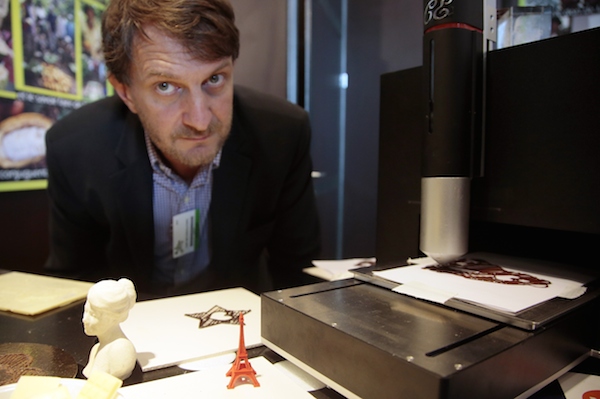 Le 30 octobre 2015, le directeur WiShape, Bertrand Busson, pose à côté de son imprimante 3D Choc Creator, sur son stand lors du Salon du Chocolat à la Porte de Versailles. (JACQUES DEMARTHON/AFP/Getty Image)