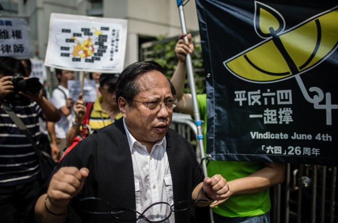 Albert Ho du Parti démocrate de Hong Kong porte de fausses menottes lors d’une manifestation à Hong Kong le 12 juillet 2015, suite à l’arrestation de plus de cinquante avocats et militants des droits chinois. M. Ho est l'un des fondateurs du China Human Rights Lawyers Concern Group (CHRLCG), qui est à l’initiative d’une récente lettre. (Anthony Wallace / Getty Images)