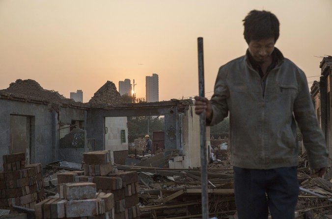 Des ouvriers chinois démolissent une maison dans le village de Gucheng, district de Tongzhou à Pékin, le 16 octobre 2015. Les bureaux municipaux de la capitale vont quitter le centre-ville, pour s’installer en banlieue dans le cadre d'un projet gouvernemental ambitieux de créer une mégapole dans le nord de la Chine (Kevin Frayer/Getty Images)