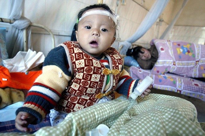 Une petite fille partage une chambre avec sa mère à la  maternité de Yulin, province du Guangxi, le 9 décembre 2004. Une mère est décédée en Chine suite à un neuvième avortement. (Frederic J. Brown / AFP / Getty Images)