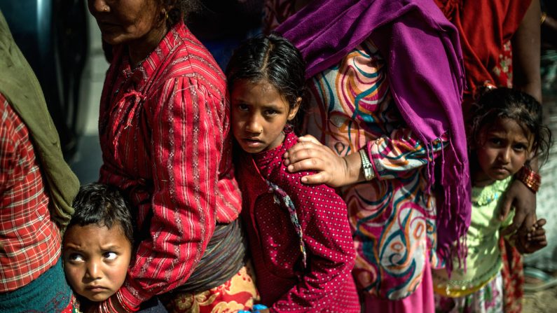 Des victimes du tremblement de terre font la queue sur une route afin de recevoir de la nourriture et des articles de première nécessité à un point de distribution d’aide à Bhotechaur, Népal, le 1er mai 2015. (David Ramos/Getty Images)