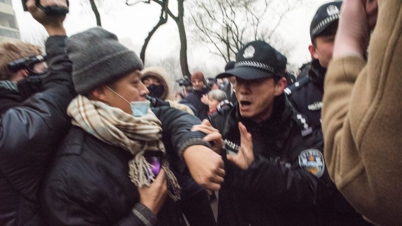 Des policiers chinois repoussent des journalistes et des sympathisants de l'avocat des droits de l'homme Pu Zhiqiang qui manifestaient  près du Tribunal intermédiaire No 2  de Pékin, le 14 décembre 2015. (FRED DUFOUR / AFP / Getty Images)