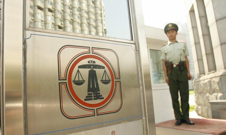 Un policier paramilitaire chinois se tient devant la Cour Intermédaire No. 2 de Pékin. Les avocats chinois expliquent que le système légal chinois est contrôlé par le Parti Communiste, pas par un État de droit. (Peter Parksp/AFP/Getty Images) 