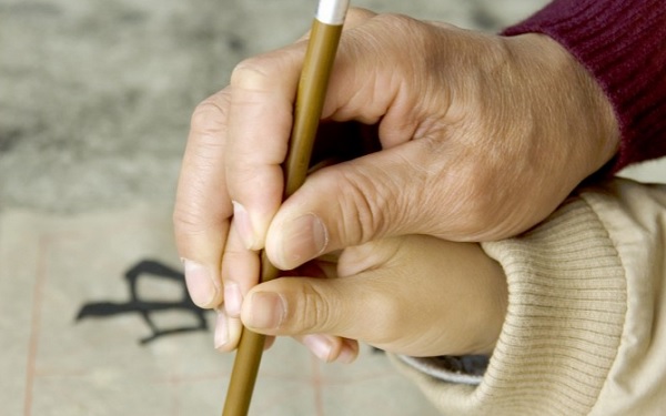 Un père enseigne la calligraphie chinoise à un enfant, une forme d’art qui s’est développée au cours de nombreux siècles, comprenant des dimensions esthétiques telles que le rythme, le design, la précision et la beauté. (Fergus Wang/Fotolia)
