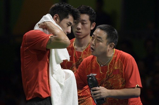 Le joueur chinois Zhang Jike (g) est conseillé par son entraîneur Liu Guoliang (d) après avoir perdu le match de demi-finales contre la Corée du Sud lors des Jeux olympiques de Rio 2016, à Rio de Janeiro, le 15 août 2016. (JUAN MABROMATA / AFP / Getty Images)