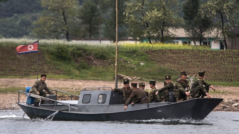 Les soldats nord-coréens utilisent un bateau comme ferry local alors qu'ils traversent la rivière Yalu. (Kevin Frayer/Getty Images)