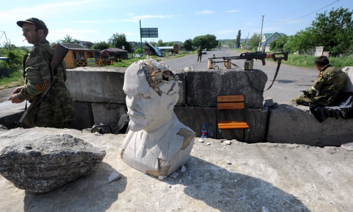 Les séparatistes armés pro-russes gardent un poste de contrôle avec un buste de Lénine dans le village de Semenovka, près de Slavyansk, dans l'est de l'Ukraine, le 22 mai 2014. (VIKTOR DRACHEV / AFP / Getty Images)