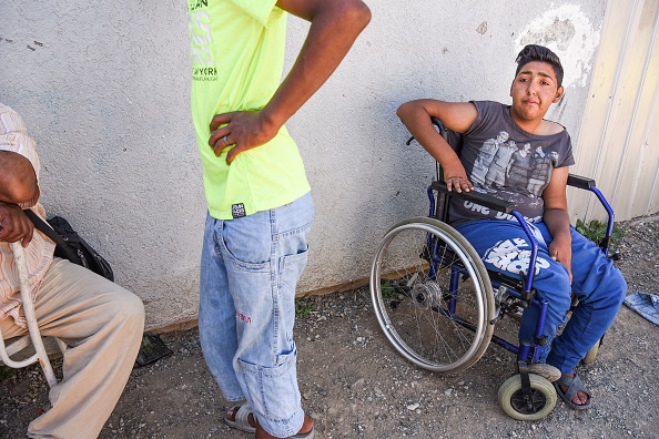 Jetullah Veliu, 16 ans, est assis en chaise roulante le long de la route dans le quartier Rom de Mitrovica en juillet 2017. ( ARMEND NIMANI/AFP/Getty Images)