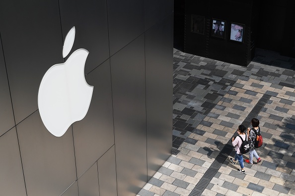 Des Chinois passent devant un magasin Apple le 3 août 2017 à Pékin. GREG BAKER/AFP/Getty Images)