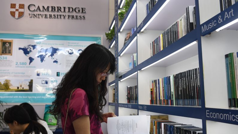 Une femme lit un livre au stand de Cambridge University Press à la Foire internationale du livre de Pékin, le 23 août 2017. Malgré le scandale provoqué par la tentative de censurer en Chine un journal académique britannique, des centaines de maisons d'édition internationales essayent d’attirer les importateurs chinois lors d'une importante foire du livre à Pékin. (GREG BAKER / AFP / Getty Images)