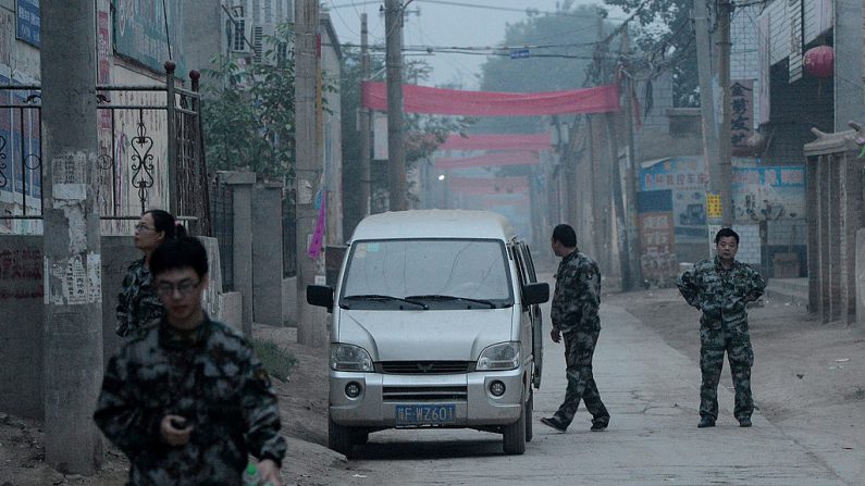 La sécurité chinoise patrouille les rues, avant un défilé chrétien près de la cathédrale de Donglu, dans la province du Hebei, pour empêcher les villageois et les pèlerins de se joindre au défilé honorant la Vierge Marie. (Photo de MARK RALSTON/AFP/Getty Images)