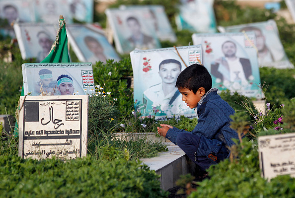 Un enfant du Yémen se recueille devant une tombe d'un proche dans le cimetière de la capitale de Sanaa. (MOHAMMED HUWAIS/AFP/Getty Images)