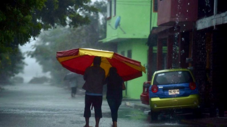 Un couple marche sous les fortes pluies avant l'arrivée de Katia à Tecolutla, au Mexico le 8 septembre 2017. (Photo de YURI CORTEZ/AFP/Getty Images)