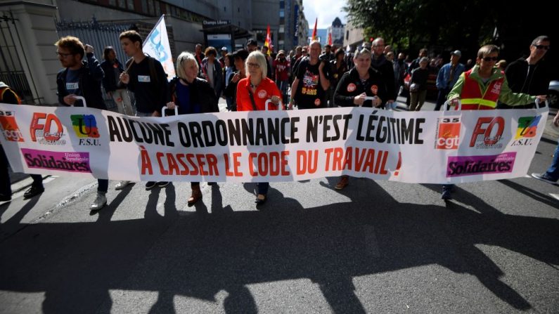 Des manifestants tiennent une bannière contre les réformes au code du travail le 12 septembre 2017. 
(Photo de DAMIEN MEYER/AFP/Getty Images)