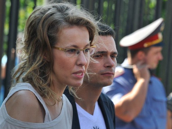 L'un des dirigeants de l'opposition, Ilya Yashin (au fond) et la militante de l'opposition et célébrité médiatique Ksenia Sobchak (G) se tiennent à l'entrée d'un bureau de la Commission fédérale d'enquête à Moscou, le 15 juin 2012, d'une enquête sur le rassemblement du mois dernier organisé à la veille de l'inauguration de Poutine, qui s'est soldée par de violents affrontements entre manifestants et policiers. Les dirigeants de l'opposition sont actuellement interrogés en tant que témoins et n'ont pas été accusés de crimes liés à cette manifestation. (ALEXANDER NEMENOV / AFP / GettyImages)