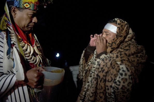 un guérisseur fait une cérémonie offrant de la liane hallucinogène de l'Ayahuasca . Ce genre de cérémonies attire de nombreuses personnes en Amérique du Sud qui cherchent à participer à un rituel autochtone traditionnel de guérison spirituelle et physique impossible à réaliser dans de nombreux pays où ces plantes sont considérées comme des drogues.(EITAN ABRAMOVICH / AFP / Getty Images)