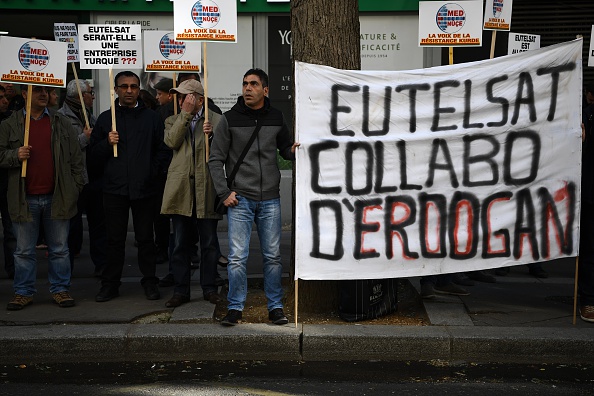 Des militants kurdes organisent une manifestation devant le siège d'Eutelsat à Paris le 6 octobre 2016. L'opérateur européen de télévision par satellite Eutelsat a déclaré le 5 octobre 2016 avoir retiré le diffuseur kurde Med-Nuce TV à la demande des autorités turques, dans un geste condamné comme une extension de la répression des médias d'Ankara au-delà des frontières de la Turquie. 
Ce n'est pas la première fois qu'Eutelsat censure des chaînes de télévisions libres pour plaire à des dictatures.
(CHRISTOPHE ARCHAMBAULT / AFP / Getty Images)