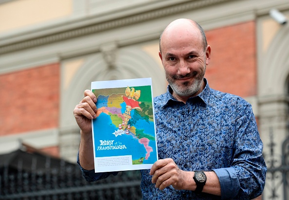 Jean-Yves Ferri pose avec la couverture du 37e album "Astérix et la Transitalique" le 5 avril 2017 à Bologne, Italie. (MIGUEL MEDINA/AFP/Getty Images)