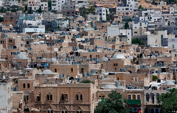 Une photo prise le 29 juin 2017 montre une vue sur les maisons de la vieille ville de la ville divisée d'Hébron dans le sud de la Cisjordanie. Le 7 juillet 2017, l'UNESCO a déclaré au scrutin secret la vieille ville d'Hébron, "site protégé du patrimoine". Hébron abrite plus de 200 000 Palestiniens et quelques centaines de colons israéliens qui vivent dans une enclave fortement fortifiée près du site connu des musulmans comme "La mosquée d'Abraham"  et des Juifs comme "Le caveau des Patriarches". 
(HAZEM BADER / AFP / Getty Images