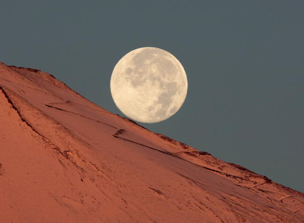 La lune vue depuis le Mont Fuji enneigé. (Koichi Kamoshida/Getty Images)