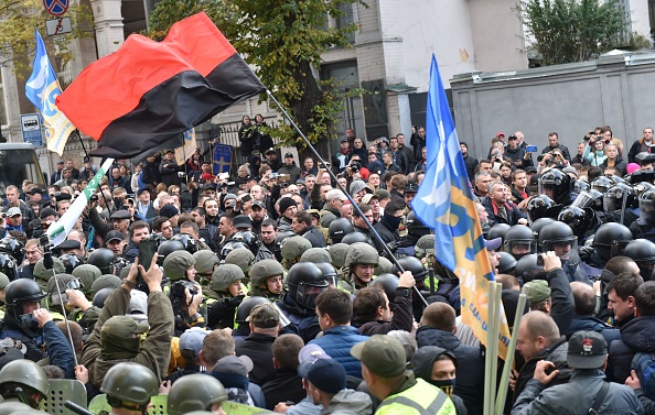 Les manifestants se heurtent à la police lors d'un rassemblement de l'opposition ukrainienne devant le parlement à Kiev le 17 octobre 2017. Mikheil Saakashvili, l'ancien chef de la Géorgie, a déclaré à un rassemblement à Kiev le 17 octobre 2017 que le président Petro Porochenko avait besoin de faire -corriger les réformes ou laisser le pouvoir si les Ukrainiens devaient voir le changement dans leur pays. Le rassemblement en dehors du parlement ukrainien à Kiev a été appelé par plusieurs partis politiques dont celui de Saakashvili, qui a profité de l'occasion pour rallier les partisans après un retour spectaculaire en Ukraine en septembre. (SERGEI SUPINSKY / AFP / Getty Images)