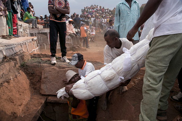 Tradition funéraire appelée "Famadihana" dans le village d'Ambohijafy, à quelques kilomètres d'Antananarivo, le 23 septembre 2017. 
Pendant la Famadihana, qui peut être traduite par «tourner les os», plusieurs cryptes sont ouvertes et les gens prennent les corps de leurs ancêtres dans les cryptes de la famille et les remballent dans du tissu frais, puis dansent avec les cadavres dans les bras au rythme de la musique traditionnelle malgache. Le Famadihana est un pilier du culte des ancêtres malgaches et est célébré tous les trois, cinq ou sept ans. (RIJASOLO / AFP / Getty Images)