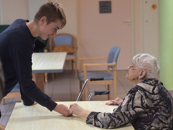 Un adolescent tient la main d'une femme atteinte de la maladie d'Alzheimer dans une maison de retraite le 18 octobre 2016 à Saint Quirin, dans l'est de la France.
(PATRICK HERTZOG / AFP / Getty Images)