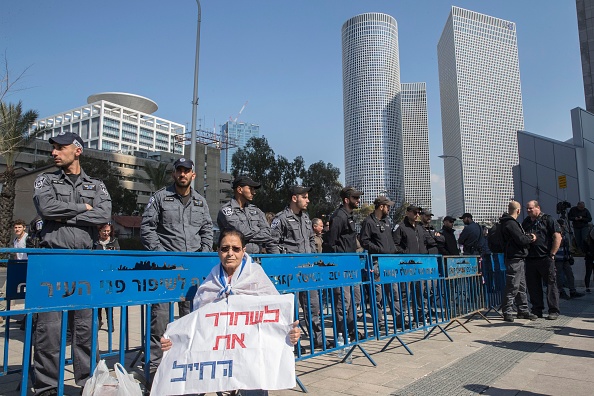 Une femme israélienne tient une affiche en hébreu: "libérez le soldat" devant le ministère de la Défense à Tel Aviv le 21 février 2017, en soutien au soldat israélien Elor Azaria, qui a abattu un assaillant palestinien blessé, en attendant son verdict dans une affaire qui a profondément divisé le pays et déclenché des tensions politiques. Le tribunal militaire israélien a condamné le soldat à 18 mois de prison.
(JACK GUEZ / AFP / Getty Images)
