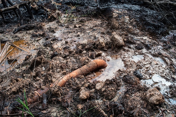 Un oléoduc sur le site d'une raffinerie de pétrole illégale lors d'une patrouille le 19 avril 2017 dans la région du Delta du Niger près de la ville de Warri. Les structures illégales, qui fonctionnent grâce au siphonnage des oléoducs des grandes compagnies pétrolières, sont, selon l’armée, la principale source de financement des groupes armés.
(STEFAN HEUNIS / AFP / Getty Images)