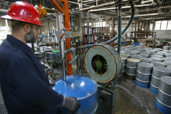 Un travailleur de la raffinerie de Dura, dans la banlieue sud de Bagdad, remplissant un baril de «light sweet crude». 
(KARIM SAHIB / AFP / Getty Images)