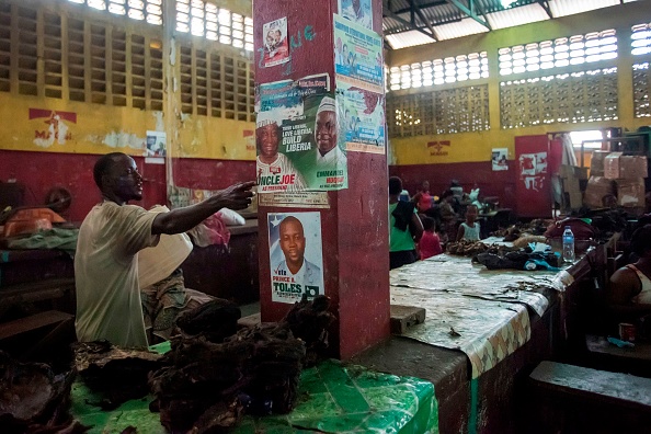 Des affiche électorale de Joseph Boakai, candidat à l'élection présidentielle du parti libérien Unity Party, au marché du Rally Time, à Monrovia, le 13 octobre 2017. 
Le Centre Carter --fondation créée par l'ancien président américain Jimmy Carter pour promouvoir la démocratie et les droits de Homme dans le monde-- a prévenu que le risque de tensions augmenterait proportionnellement à la durée du report de l'élection.
(CRISTINA ALDEHUELA / AFP / Getty Images)