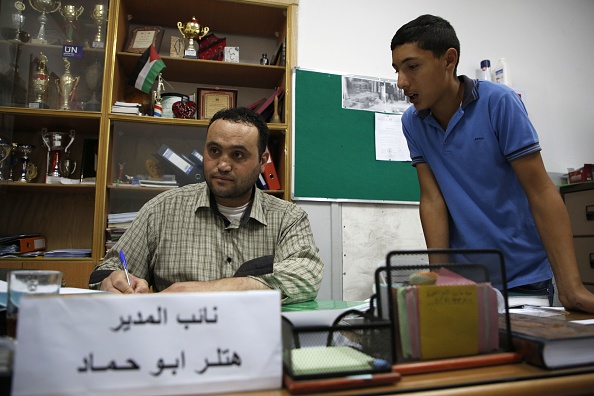 Le Palestinien Hitler Abu Hamad, directeur adjoint d'une école, travaille à son bureau dans la ville israélienne d'Hébron, le 26 septembre 2017. Hitler, Castro et Saddam Hussein se rencontrent dans un bar. Cela peut sembler le début d'une blague, mais dans les territoires palestiniens, c'est effectivement possible. 
(HAZEM BADER/AFP/Getty Images)