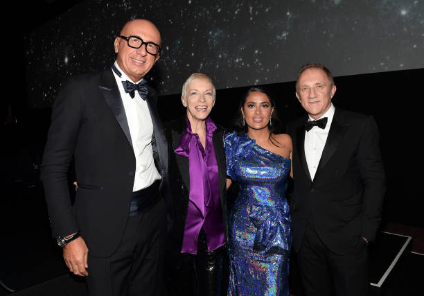 La chanteuse Annie Lennox (en violet) entourée du PDG de Gucci Marco Bizzarri (G), de l'acteur Salma Hayek et du Président-Directeur Général de Kering François-Henri Pinault au Gala Art + Film LACMA 2017. 
(Matt Winkelmeyer / Getty Images pour LACMA)